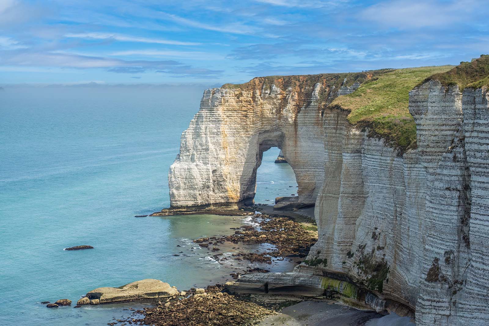 Étretat is best known for its chalk cliffs, including three natural arches and a pointed formation called L'Aiguille or the Needles © Shutterstock