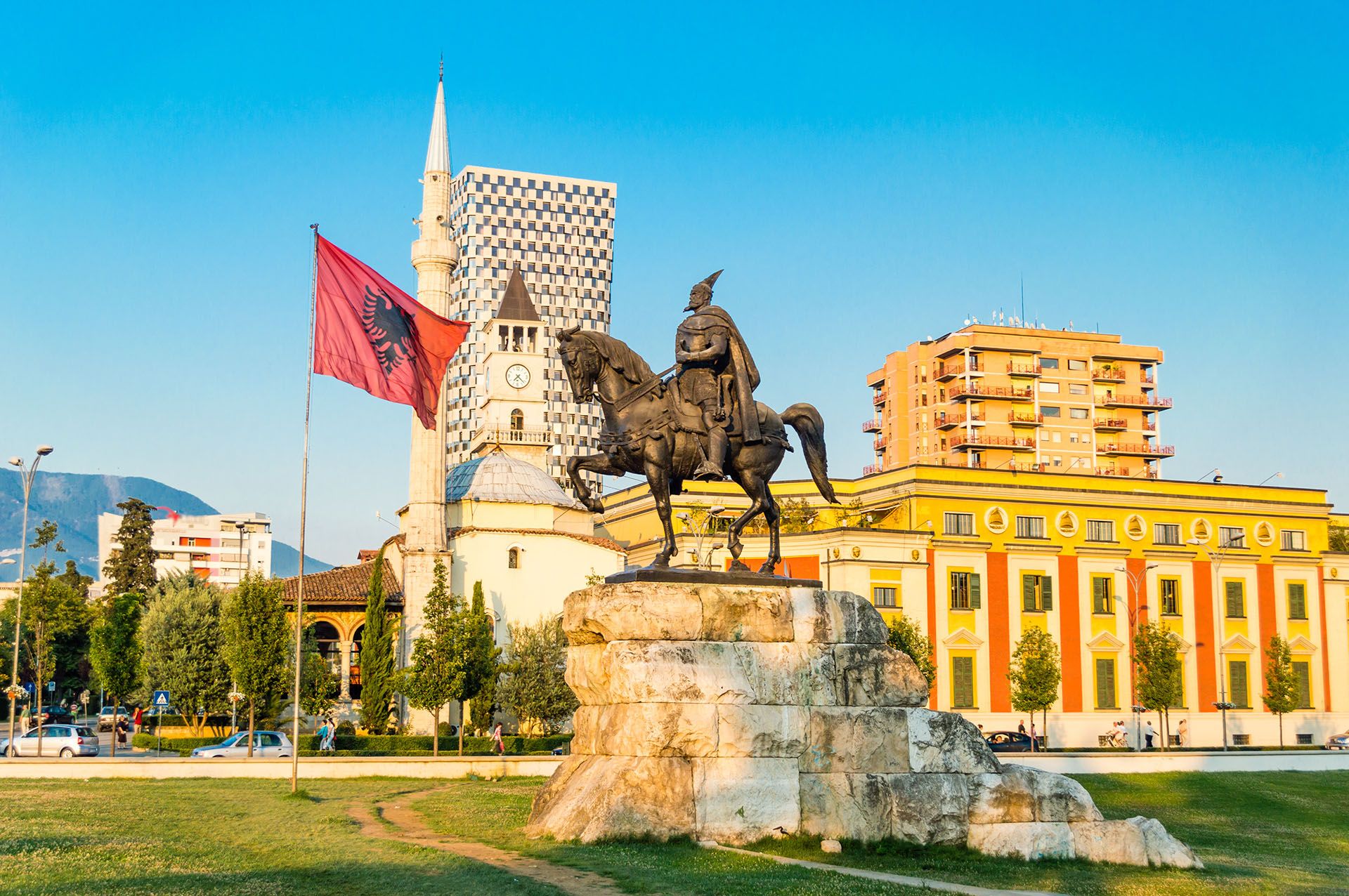 Skanderbeg square with flag, Skanderbeg monument, The Et'hem Bey Mosque and Clock Tower in the center of Tirana city, Albania © AdobeStock