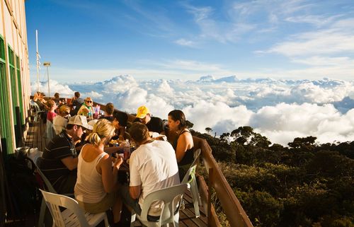 Hikers enjoy lunch above the clouds at Laban Rata resthouse, on Mt Kinabalu. Kinabalu National Park, Sabah, Borneo, Malaysia